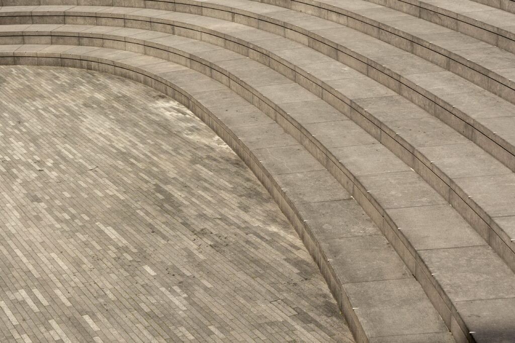 Curved stone amphitheater steps with textured tiles. Ideal for architectural concepts.